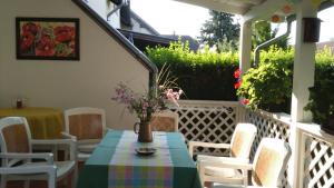 un patio con mesa y sillas en un porche en Csilla Haus, en Bük