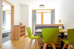 a dining room with green chairs and a table at White Peak in Galtür