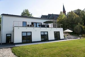 ein weißes Haus mit schwarzen Fenstern und Rasen in der Unterkunft Villa WallAnn in Morbach