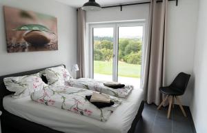 a bedroom with a bed and a large window at Villa WallAnn in Morbach