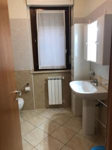 a bathroom with a sink and a toilet and a window at Casa MALÙ 2 in Latina