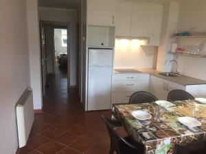 a kitchen with a table and a white refrigerator at Porto de Espasante -Severino Blanco in O Porto de Espasante