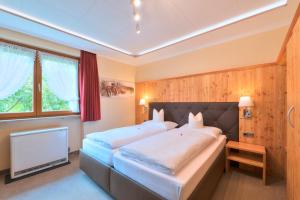 a bedroom with two beds and a flat screen tv at Das Elisabeth in Sankt Anton am Arlberg