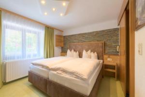 een slaapkamer met een groot bed met een bakstenen muur bij Das Elisabeth in Sankt Anton am Arlberg