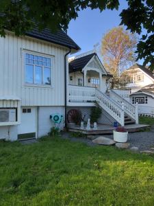 a white house with a porch and stairs at Dragon Villa Reine in Reine