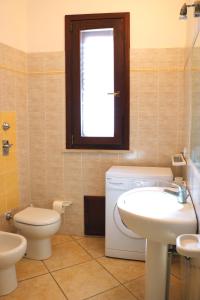 サン・ヴィート・ロ・カーポにあるBluvacanze Appartamento Stellaのバスルーム(洗面台、トイレ付)、窓が備わります。
