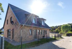 a brick house with a black roof on a street at Haus Sternstunden in Bansin