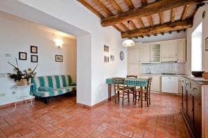 een keuken en een woonkamer met een tafel en stoelen bij Agriturismo Il Sambuco in Siena