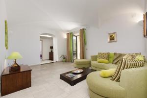 een woonkamer met 2 banken en een tafel bij Amore Rentals - Villa Il Noce in SantʼAgata sui Due Golfi