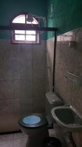 a bathroom with a toilet and a sink and a window at Suítes Pouso do Sol in Praia de Araçatiba +136 photos