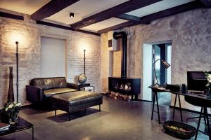 a living room with a leather couch and a fireplace at Fisher's Loft Hotel in Lübeck