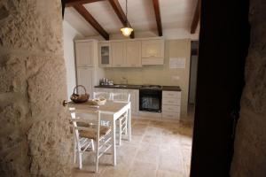 una cucina con un tavolo bianco e sedie di Trullo Rinaldi - Private Pool and Sauna a Castellana Grotte