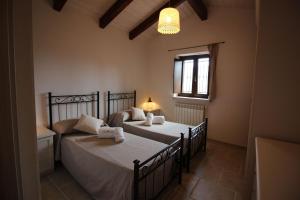 una camera da letto con due letti e una finestra di Trullo Rinaldi - Private Pool and Sauna a Castellana Grotte Altre 55 foto