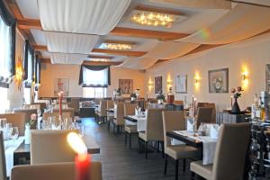 ein Esszimmer mit weißen Tischen und Stühlen in der Unterkunft Hotel Restaurant Doppeladler in Rees
