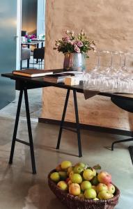 einen Tisch mit einem Korb mit Äpfeln und Weingläsern in der Unterkunft Fisher's Loft Hotel in Lübeck