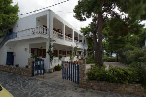 a white house with a tree and a fence at Maria Studios in Patitiri