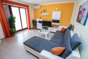 uma sala de estar com um sofá azul e uma televisão em Apartments Mare em Porec