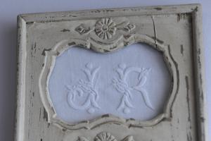 un cadre blanc avec une décoration florale sur un mur dans l'établissement Chambres d'Hôtes la Maison de Juliette, à Valentigney