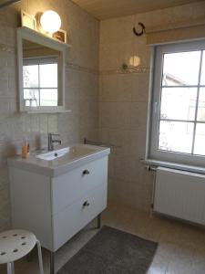 ein Bad mit einem weißen Waschbecken und einem Fenster in der Unterkunft Parkland-Haus Dalwitz in Walkendorf