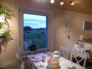 ein Esszimmer mit einem Tisch und einem Fenster mit einem Pferd im Freien in der Unterkunft Parkland-Haus Dalwitz in Walkendorf