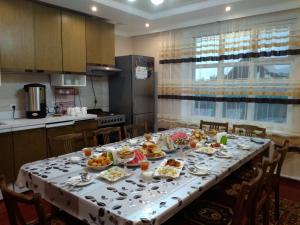 a table with plates of food on it in a kitchen at Meerim Guest House in Bokonbayevo