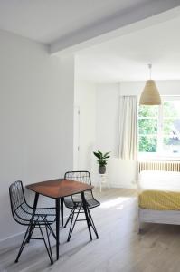 een woonkamer met een tafel en stoelen en een bed bij B&B Villa Bon Papa in De Panne