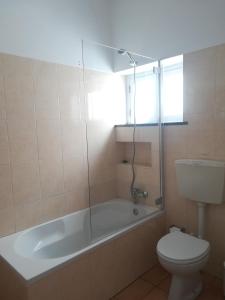 a bathroom with a tub and a toilet and a sink at Pirata hostel Milfontes in Vila Nova de Milfontes