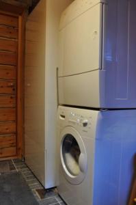 a laundry room with a washing machine and a refrigerator at Villa Rukapiste in Ruka