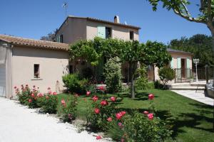 einen Garten vor einem Haus mit Rosen in der Unterkunft Gite des Taillades in Les Taillades