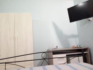 a bedroom with a bed and a desk with a television at Palazzo Mosca in Sannicola
