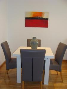 a table with chairs and a vase on top of it at Apartamento Torres in Valencia