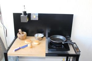 a counter with a stove with a frying pan on it at Studio 237 Port Camargue, Piscine, Climatisation, 2 personnes in Le Grau-du-Roi