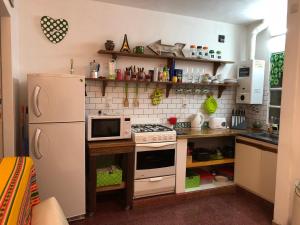 cocina con nevera blanca y microondas en Cozy, Bright, near everything./Cómodo, luminoso, cerca de todo. en Rosario