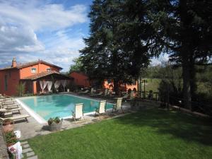 - une piscine dans une cour avec des chaises et une maison dans l'établissement Agriturismo Villa Le Vigne, à Montevarchi