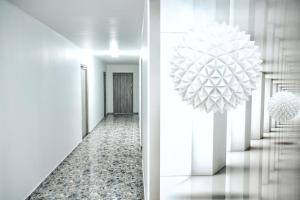 a hallway with white walls and a chandelier at S-HOF in Sonnenbühl