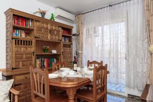un comedor con una mesa con sillas y una ventana en Apartament Ania, en Torrevieja