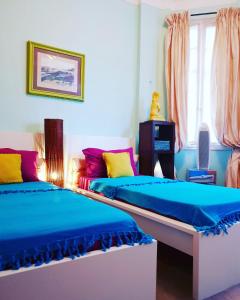 two beds in a room with blue and pink at Home for 2 few steps from center of Monte Carlo in Beausoleil +76 photos