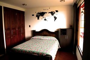 1 dormitorio con 1 cama con mapa en la pared en Mirador de los Cedros, en Salento