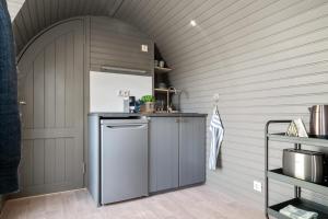 StrandlykkjaKonglehytta的厨房配有灰色冰箱和拱门