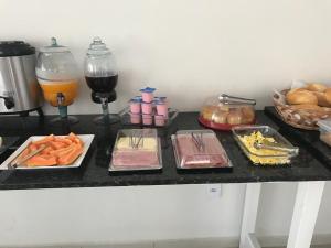 una mesa cubierta con platos de comida y una copa de vino en Leati's Hotel, en Marília