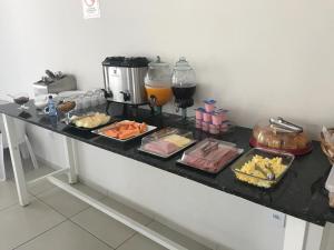 una mesa con muchos alimentos diferentes en ella en Leati's Hotel, en Marília