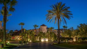 Una calle con palmeras frente a un resort. en Precise Resort El Rompido-The Club, en El Rompido