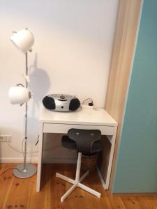 a white desk with a telephone and a chair at Lodge Berlin - Apartments in Berlin