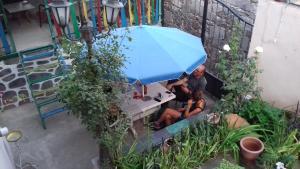 a man and woman sitting at a table under a blue umbrella at Lovely Goris in Goris