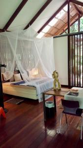 a bedroom with a bed with a mosquito net at Mar Verde Lodge in Puerto Viejo