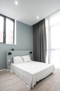 a bedroom with a large white bed and windows at NOCNOC - La Villa Cachee in Lille