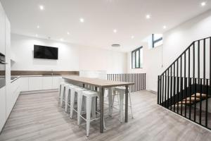 a kitchen and dining room with a table and stools at NOCNOC - La Villa Cachee in Lille