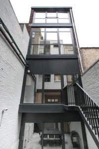 a tall glass building with a spiral staircase at NOCNOC - La Villa Cachee in Lille