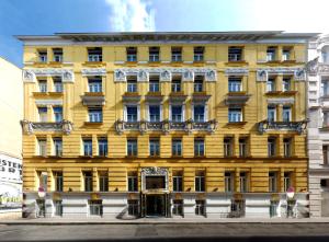 a yellow building on the corner of a street at Carlton Boutique Hotel - NEW OPENING in Vienna