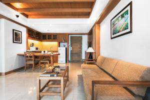 a living room with a couch and a kitchen at Green Residence Ayutthaya - SHA Certified in Phra Nakhon Si Ayutthaya